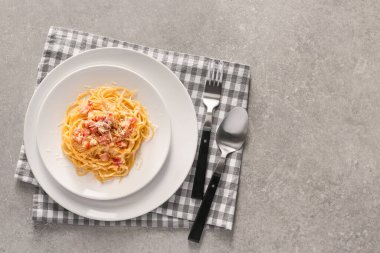 Plate with tasty pasta carbonara on grey background