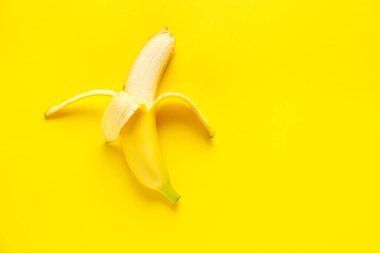 Renk arkaplanında olgun soyulmuş muz