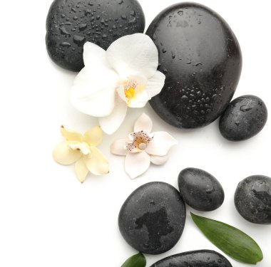 Beyaz arkaplanda spa taşları ve çiçekler