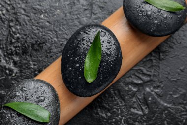 Koyu arkaplanda kaplıca taşları ve bambu yaprakları