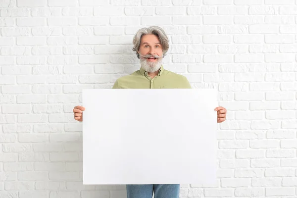 Hombre Mayor Con Cartel Blanco Sobre Fondo Ladrillo Blanco —  Fotos de Stock