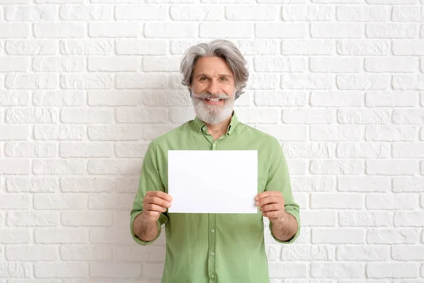 Hombre Mayor Con Tarjeta Blanco Sobre Fondo Ladrillo Blanco —  Fotos de Stock