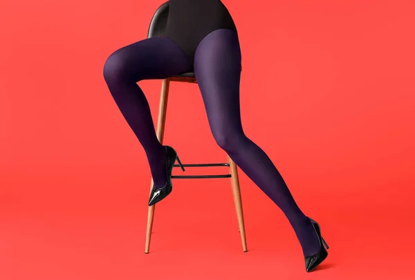 Schöne Junge Frau Strumpfhosen Sitzt Auf Stuhl Vor Farbigem Hintergrund — Stockfoto