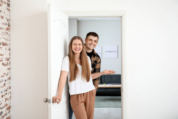 Happy couple inviting guest at their new home