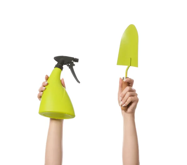 Female hands with shovel and water sprayer for gardening on white background