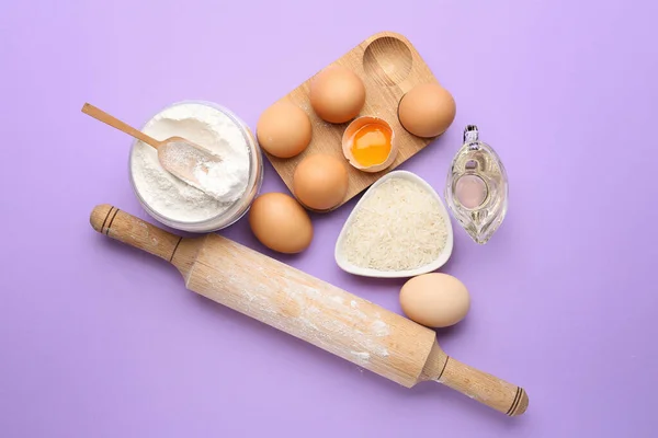 Rice flour with products on color background