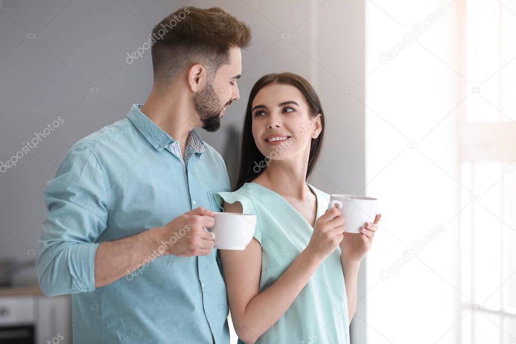 Happy young couple drinking tea at home