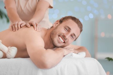Spa salonunda masaj alan yakışıklı genç adam