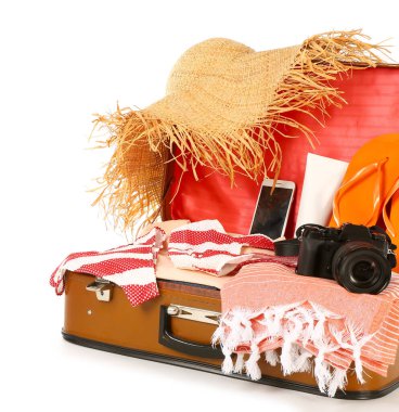Beyaz arka planda plaj aksesuarlarıyla dolu bavul. Seyahat kavramı