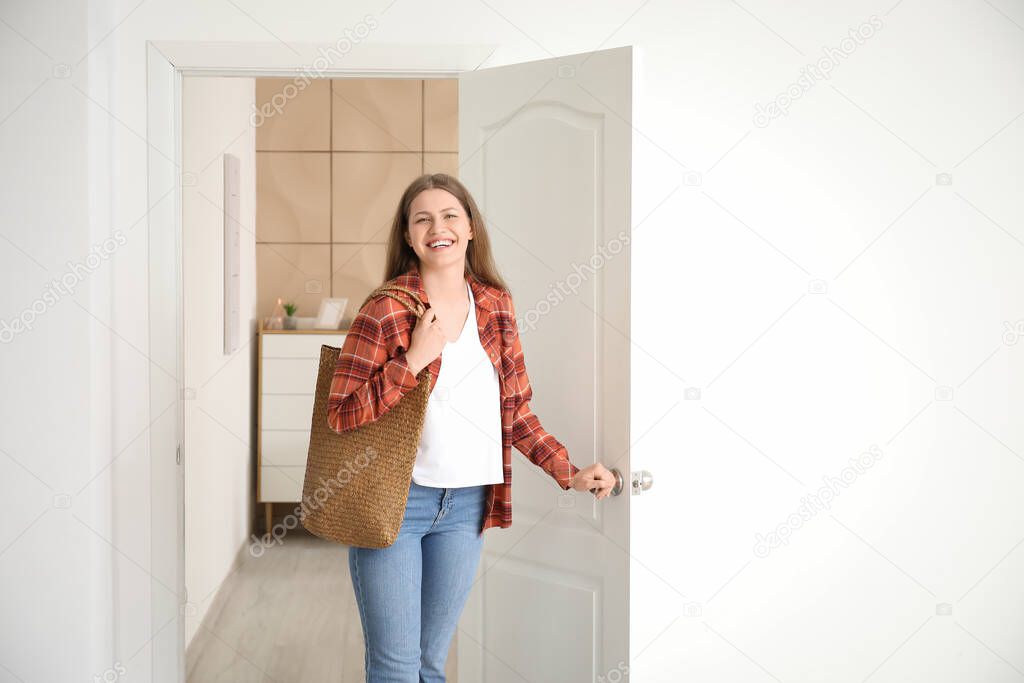 Happy woman opening door at her new home