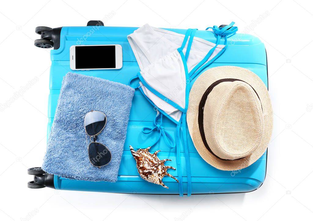 Packed suitcase with beach accessories on white background. Travel concept