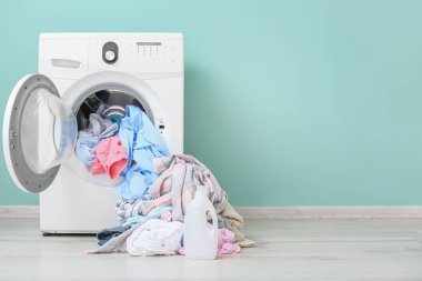 Çamaşır makinesinde kirli çamaşır ve deterjan var.