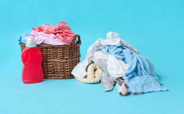 Kirli elbiseli sepet ve arka planda deterjan.