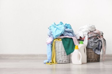 Kirli elbiseli sepetler ışık duvarının yanında.