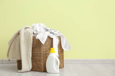 Kirli elbiseli sepet, renkli duvarın yanında.