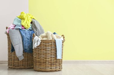 Kirli elbiseli sepetler renkli duvarın yanında.