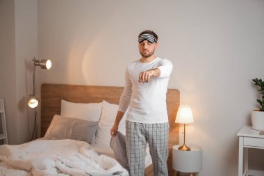 Male sleepwalker in bedroom at night clipart