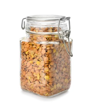 Beyaz arka planda kavanozda çiğ mercimek