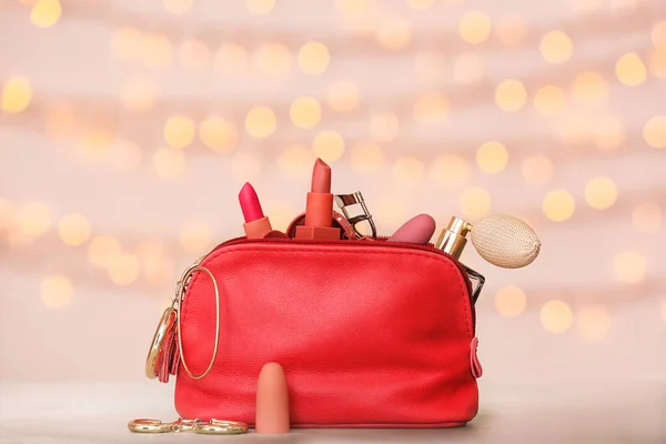 Cosmetic bag on color background with blurred lights