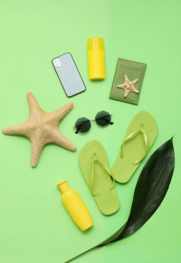 Plaj aksesuarlı cep telefonu ve renkli arka planda pasaport.