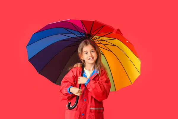かわいいです女の子でレインコートと傘で色の背景 — ストック写真
