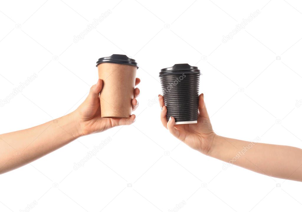 Hands with cups of hot coffee on white background
