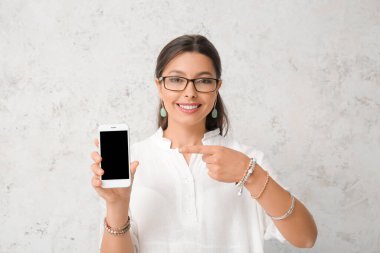 Açık arkaplanda cep telefonu olan güzel bir genç kadın.
