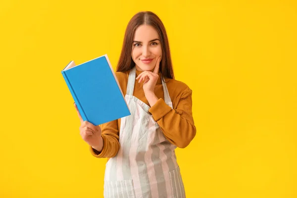 Junge Frau Mit Rezeptbuch Auf Farbigem Hintergrund — Stockfoto