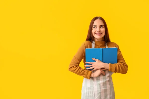 Junge Frau Mit Rezeptbuch Auf Farbigem Hintergrund — Stockfoto