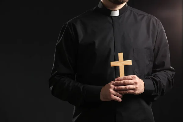 Junger Priester Mit Kreuz Auf Dunklem Hintergrund — Stockfoto