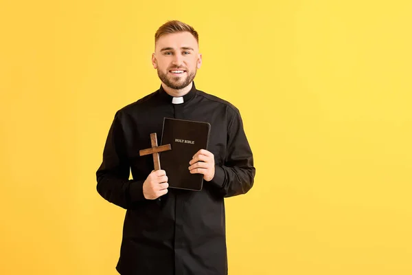 Schöner Junger Priester Mit Bibel Auf Farbigem Hintergrund — Stockfoto