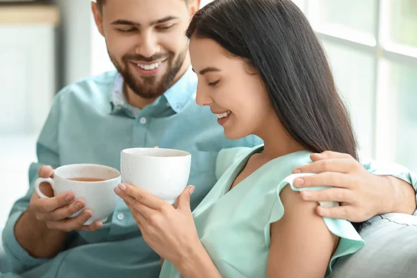 幸せな若いカップル飲むお茶に家 — ストック写真