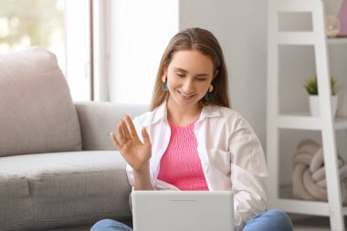 Evde dizüstü bilgisayarı olan güzel bir kadın.