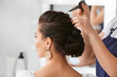 Kuaför müşteriyle güzellik salonunda çalışıyor.