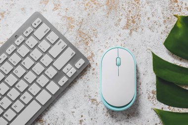 Masada bilgisayar, klavye, fare ve tropikal yaprak
