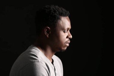 Siyah arka planda üzgün bir Afro-Amerikalı. Irkçılığı bırak