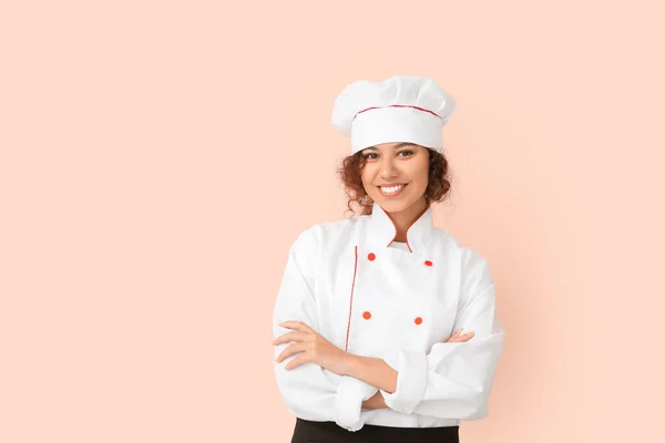 Female African-American chef on color background