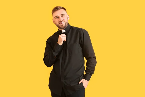 stock image Handsome young priest on color background