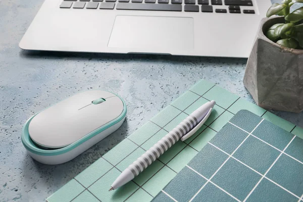 Modern laptop, mouse and stationery on table