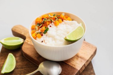 Kaynamış pirinç ve açık arkaplanda balkabağı ile kase