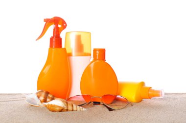 Güneş gözlüklü şişeler beyaz arkaplana karşı kum üzerinde