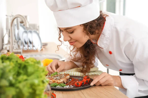 Female African-American chef cooking in kitchen