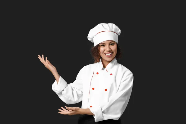 Female African American Chef Showing Something Dark Background — Stock Photo, Image