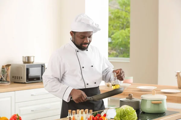 Male African-American chef cooking in kitchen