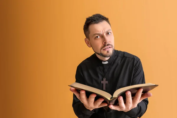 Schöner Priester Mit Bibel Auf Farbigem Hintergrund — Stockfoto