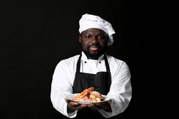 Chef Afroamericano Masculino Con Sabroso Plato Sobre Fondo Oscuro —  Fotos de Stock