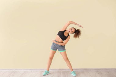 Işık duvarına karşı antrenman yapan genç bir bayan.