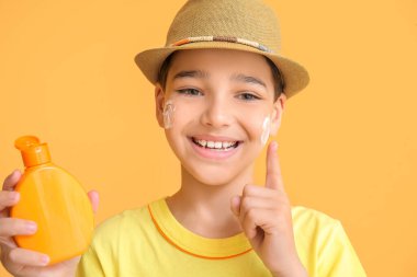 Arka planda güneş koruyucu kremi olan küçük çocuk.