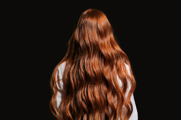 Beautiful young redhead woman on dark background