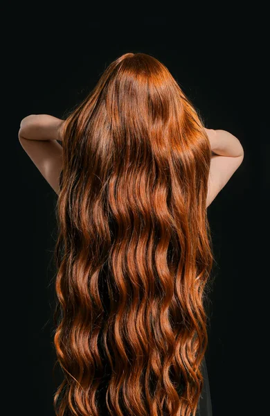 暗い背景に美しい若い赤毛の女性 バックビュー — ストック写真